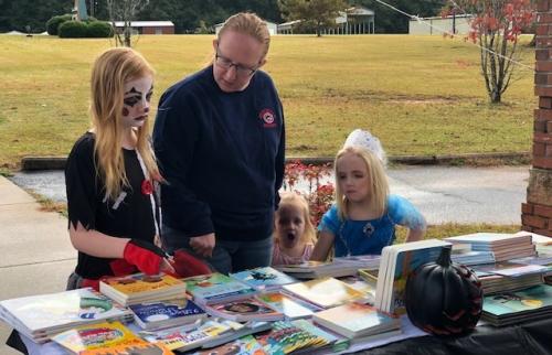 Family choosing books at Trunk or Treat event.jpg